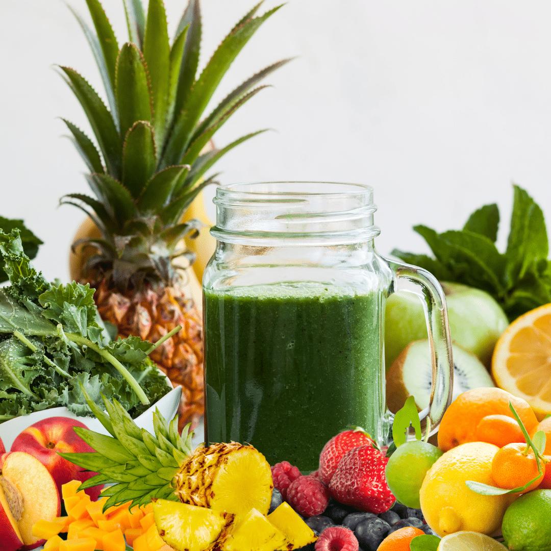 Green smoothie paired with assorted fruits
